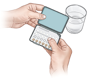 Closeup of hands holding birth control pills.