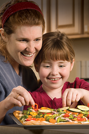 Madre e hija en la cocina preparando un bocado.