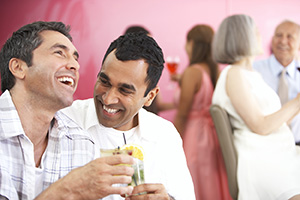 Dos hombres tomando y riendo en una fiesta
