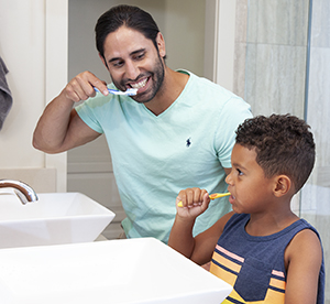 Hombre y niño cepillándose los dientes.